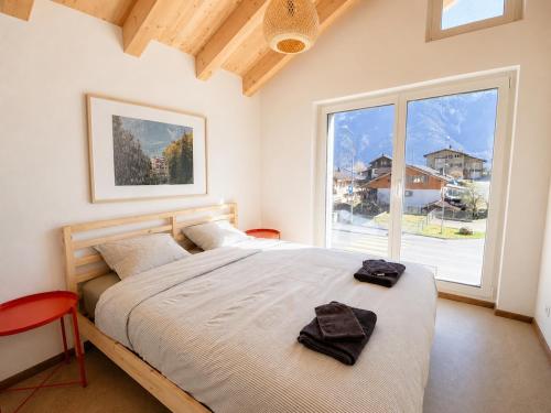 a bedroom with a bed and a large window at Hillside Loft, 2 bedrooms, max 5 guests in Ringgenberg