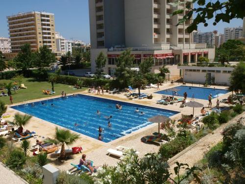 an overhead view of a large swimming pool in a city at Apartamentos Jardins da Rocha in Portimão