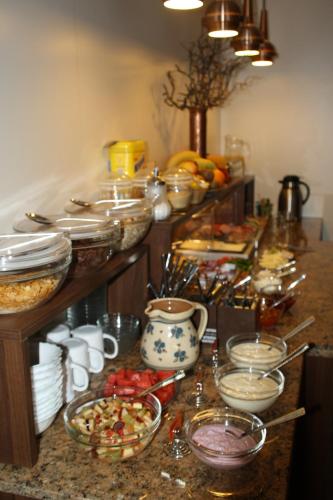 a kitchen counter with many bowls and plates of food at Pension Hotel Sartor in Kurort Altenberg