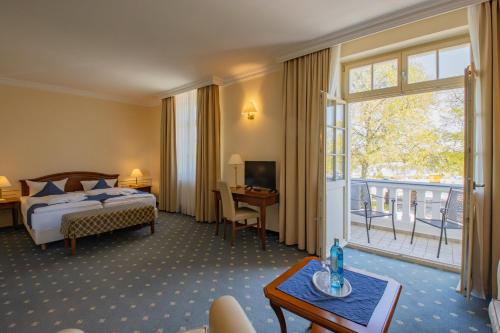 a hotel room with a bed and a large window at SeeHotel Großräschen in Großräschen