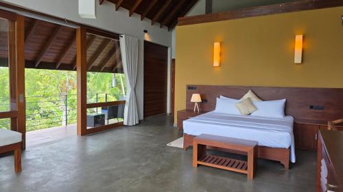 a bedroom with a bed and a large window at Moonstone herbal villa in Balapitiya
