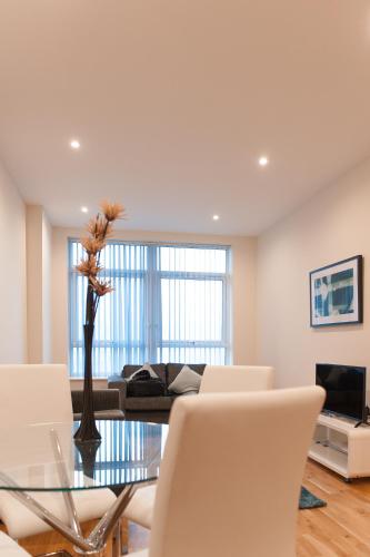 a living room with a glass table and white chairs at PSF Panorama Apartments in Ashford