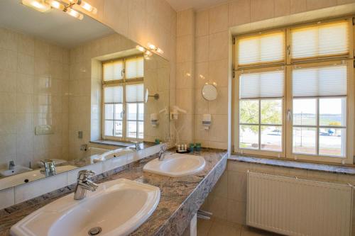 a bathroom with two sinks and a large mirror at SeeHotel Großräschen in Großräschen