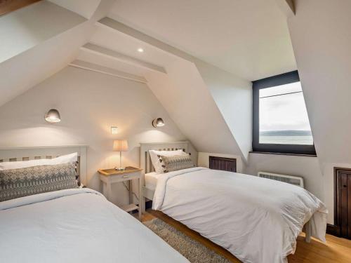 two beds in a attic bedroom with a window at 3 Bed in Isle Of Arran oc-93240 in Pirnmill