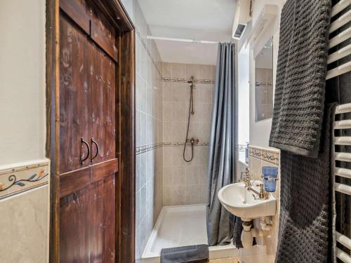 a bathroom with a wooden door and a sink and a shower at 3 Bed in Isle Of Arran oc-93240 in Pirnmill