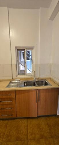 an empty kitchen with two sinks and a window at Modern Secured Condo Apartments 1 in Tema