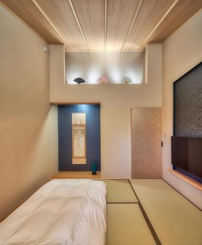 a room with a bed and a flat screen tv at 鴨川せせらぎ庵 in Kyoto