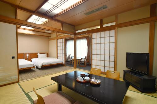 a room with a room with a bed and a television at Zekkeino Yado Inubohsaki Hotel in Choshi