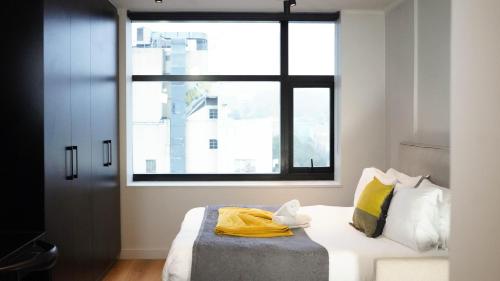 a bedroom with a bed with a large window at THE TOKYO in Cape Town