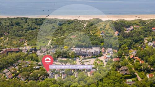 an aerial view of a town with a red sign at Welcome in - Vakantiewoning met zonnige tuin, dichtbij zee en strand I Noordendolfer 2-49 in Zoutelande
