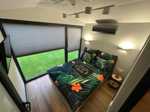a small bed in a room with a window at Domek Przy Jeziorze in Kujanki