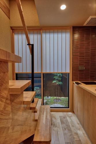 a room with wooden stairs and a large window at 鴨川せせらぎ庵 in Kyoto