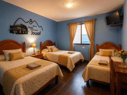 a hotel room with two beds and a sign on the wall at Hotel Jousef in Puquio