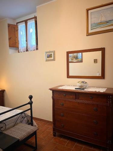 a bedroom with a wooden dresser and a mirror at Agriturismo IL VIAIO in Fiesole