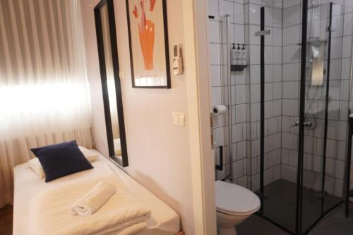 a small bathroom with a toilet and a shower at Domus Metro Hotel in Tel Aviv