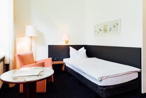 A bed or beds in a room at Parkhotel Cloppenburg