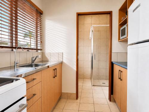 a kitchen with a sink and a shower at Teal Motor Lodge in Gisborne