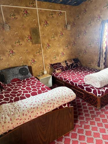 a bedroom with two beds and a wall with flowers at Nagarkot Trekkers Inn in Nagarkot