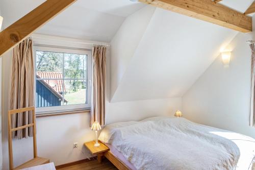 a bedroom with a bed and a window at Ferienhaus Haussee in Himmelpfort