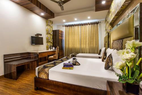a hotel room with a bed and a desk at Hotel Sunstar Heritage in New Delhi