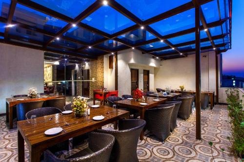 a restaurant with wooden tables and chairs with a view at Hotel Sunstar Heritage in New Delhi