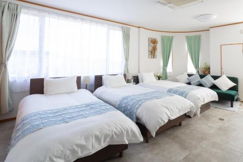 three beds sitting in a room with windows at ラベンダー富士 富士山と過ごすおしゃれな隠れ家 in Fuji