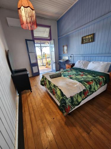 a bedroom with a bed and a wooden floor at Hotel Cecil Wondai in Wondai