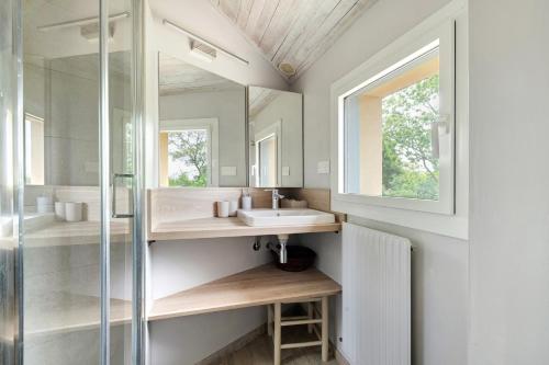 a bathroom with a sink and a mirror at Vacances chez Cali - Maison 10 pers in La Séguinière