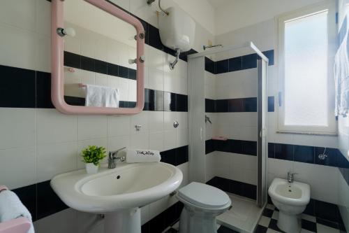 a bathroom with a sink and a toilet and a mirror at Casa Celeste a Torre dell'Orso in Torre dell'Orso