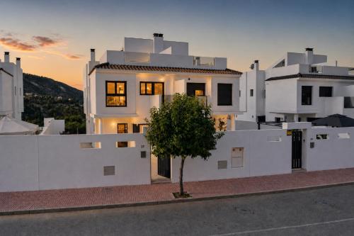 a white building with a tree in front of it at Mountain Villa with Pool by NRAS in Orcheta