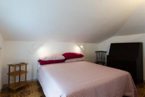 a bedroom with a bed with two red pillows at Un Nido Sul Mare in Montesilvano