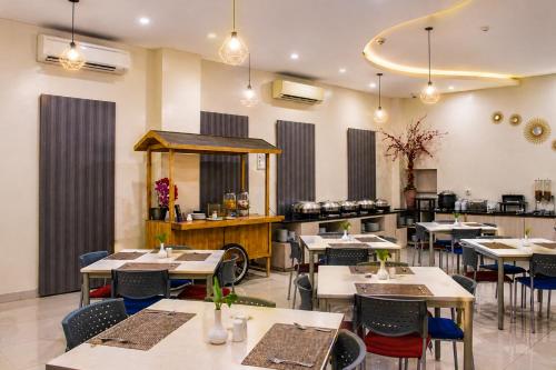 a restaurant with tables and chairs and a counter at Cordela Inn HM Yamin Medan in Medan