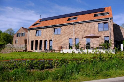 a brick house with an umbrella in front of it at Pachthof 1860 in Sint-Pieters-Leeuw