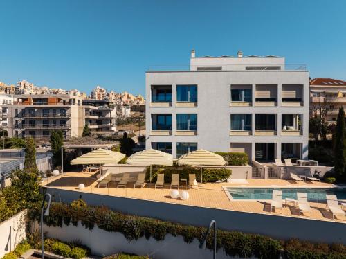 a building with chairs and umbrellas and a swimming pool at Eol Apartments Split Žnjan Beach in Split