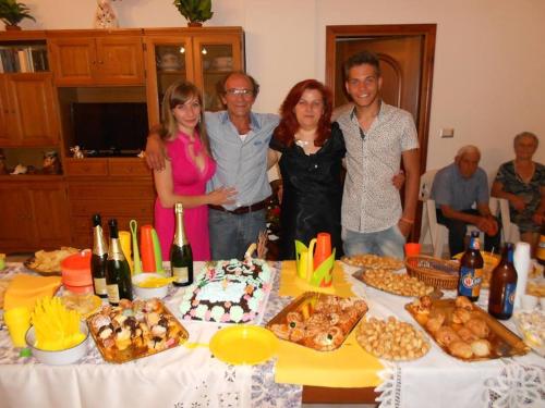 a group of people standing around a table with a cake at L'Oasi in Auletta