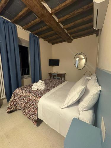 a bedroom with a large bed with blue curtains at Arco delle Apuane by Migliorini in Stazzema