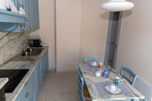 a kitchen with a table with blue chairs and a sink at Arco delle Apuane by Migliorini in Stazzema