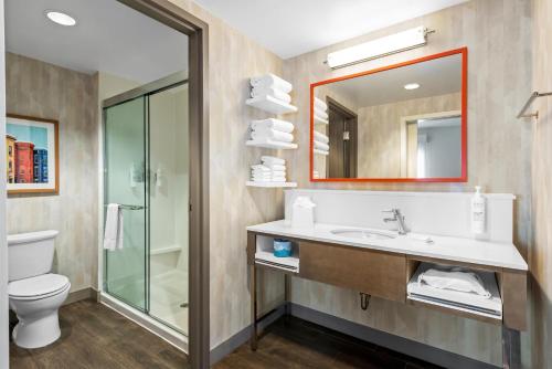 a bathroom with a sink and a toilet and a mirror at Hampton Inn & Suites Glenarden/Washington DC in Largo