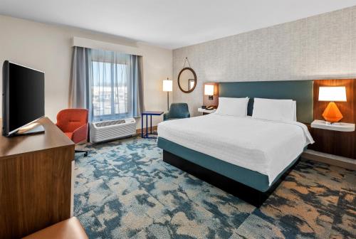 a hotel room with a bed and a flat screen tv at Hampton Inn & Suites Glenarden/Washington DC in Largo