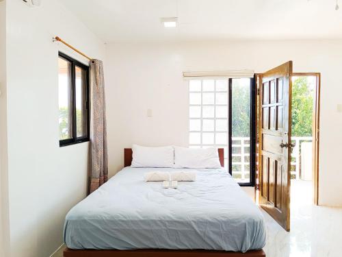 a bedroom with a bed with a towel on it at A & L Resort - Sea & Mountain View in Looc