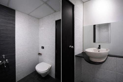 a bathroom with a white toilet and a sink at FabHotel Marvey Residency in Mumbai