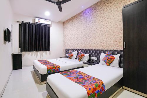 a hotel room with two beds and a tv at FabHotel Marvey Residency in Mumbai