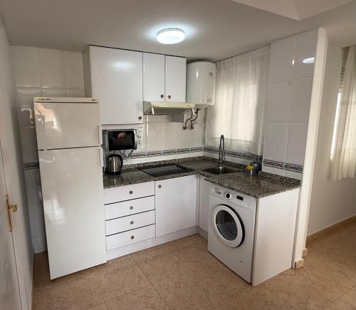 a kitchen with a white refrigerator and a washing machine at Respiro di Levante in Oropesa del Mar