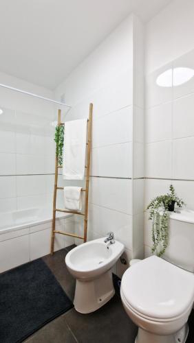 a white bathroom with a toilet and a bath tub at Island Dream Apartment in Olhão