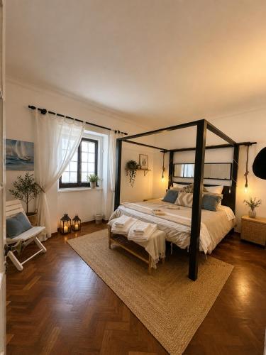 a bedroom with a large bed with a canopy at Casa dos Rebolinhos in Sagres