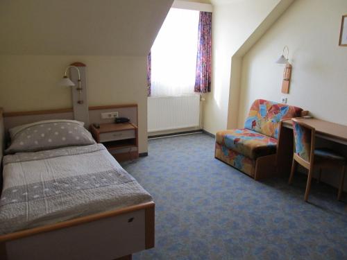 Schlafzimmer mit einem Bett, einem Schreibtisch und einem Stuhl in der Unterkunft Gasthof zum Galik in Großkrut