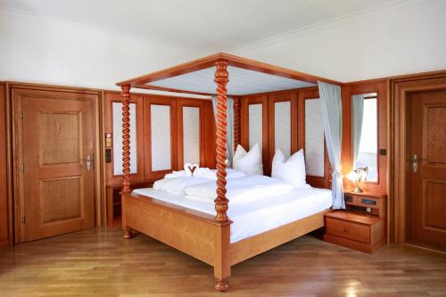 a bedroom with a canopy bed with white sheets at Schloss Maierhofen in Painten
