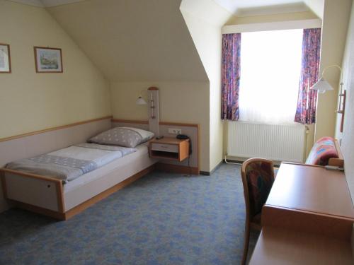 a bedroom with a bed and a table and a window at Gasthof zum Galik in Großkrut