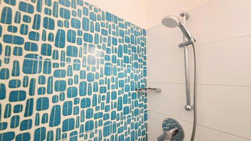 a shower with a blue and white shower curtain at Residence Capobianco in Portoferraio