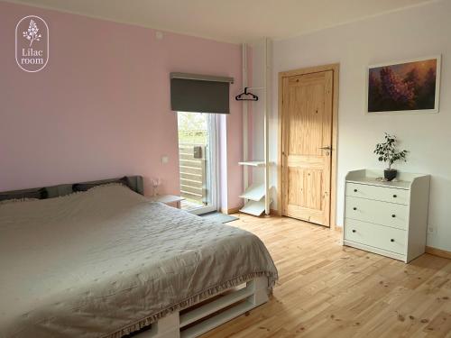 a bedroom with a bed and a dresser and a window at Lilac room in Ozolnieki